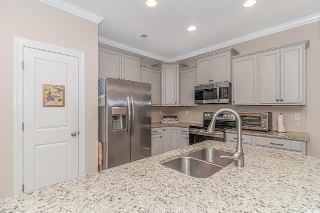 kitchen with crown molding, stainless steel appliances, light stone countertops, and decorative backsplash