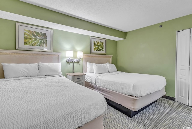 bedroom with light colored carpet and a textured ceiling