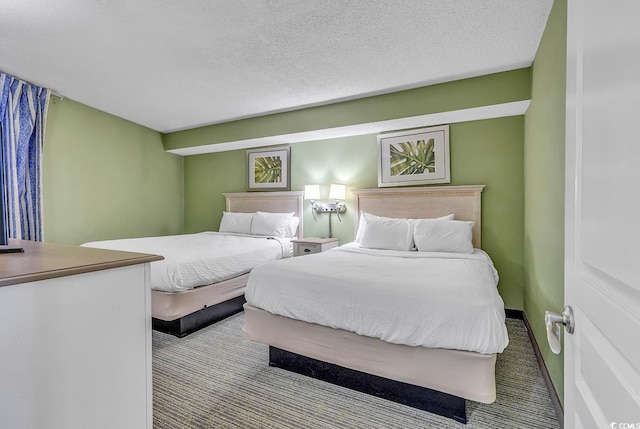 bedroom featuring a textured ceiling and light colored carpet