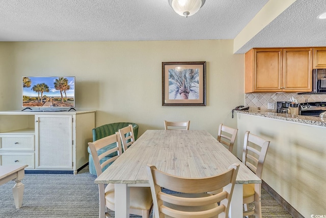 dining room with a textured ceiling and light colored carpet