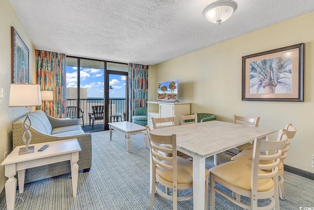 carpeted dining space featuring a textured ceiling and floor to ceiling windows