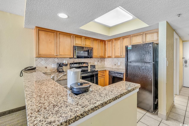 kitchen featuring light tile patterned flooring, kitchen peninsula, decorative backsplash, black appliances, and light stone countertops