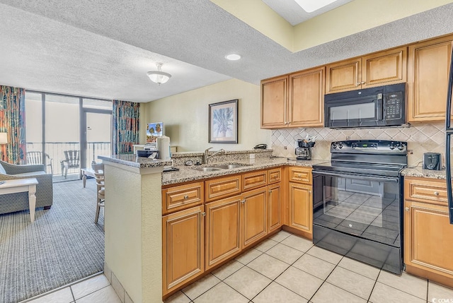 kitchen featuring sink, kitchen peninsula, decorative backsplash, black appliances, and light tile patterned floors