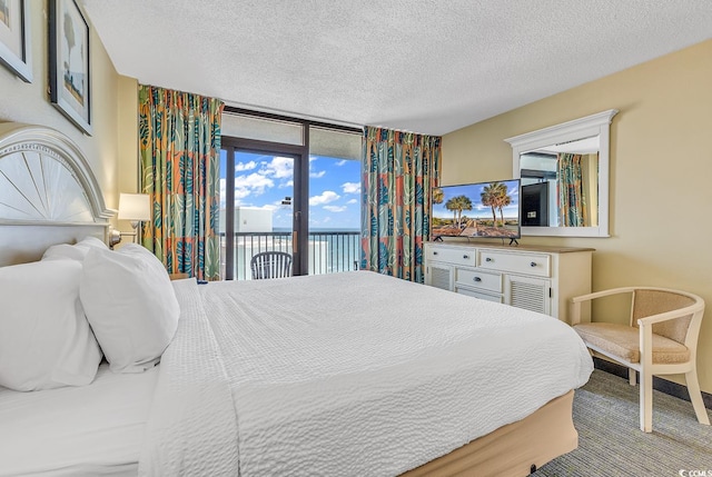 bedroom with a textured ceiling and access to exterior