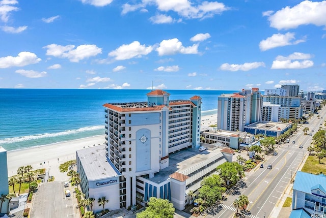 birds eye view of property with a water view and a beach view