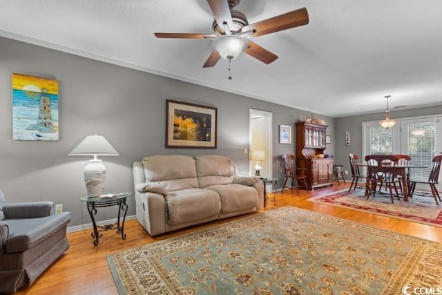 living room with ceiling fan, light hardwood / wood-style floors, and crown molding