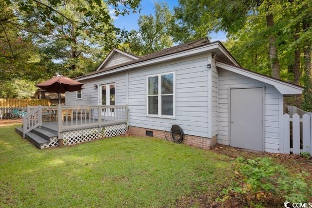 back of house featuring a wooden deck and a yard