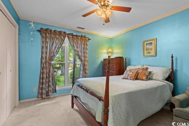 bedroom with crown molding, carpet, ceiling fan, and a closet