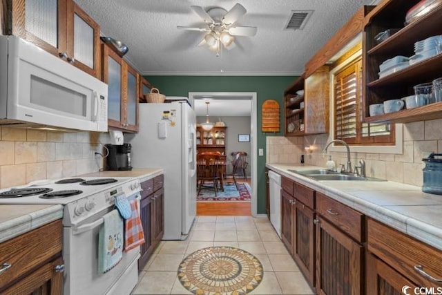 kitchen featuring ornamental molding, white appliances, a textured ceiling, sink, and ceiling fan