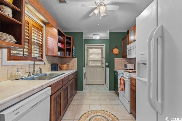 kitchen with crown molding, white appliances, light tile patterned floors, sink, and ceiling fan