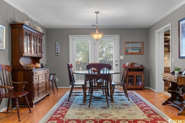 dining room with light hardwood / wood-style flooring and ornamental molding