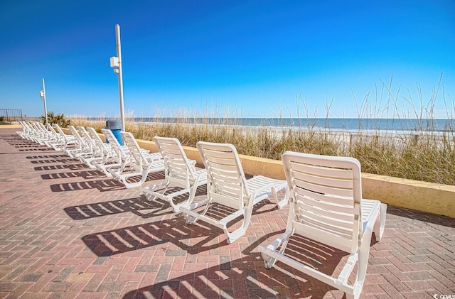 view of patio / terrace with a view of the beach and a water view