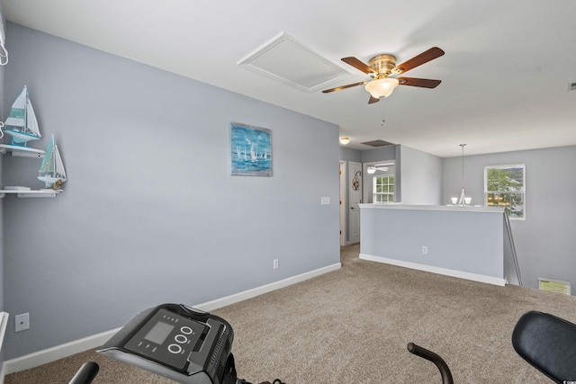 workout area featuring carpet floors and ceiling fan with notable chandelier