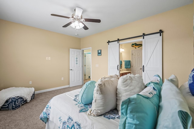 bedroom featuring carpet floors, ensuite bathroom, a barn door, and ceiling fan