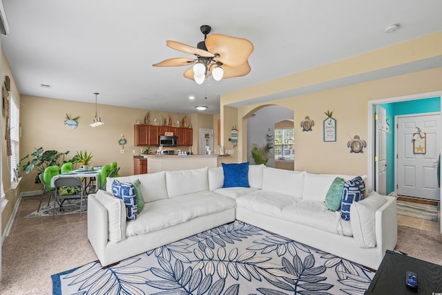 carpeted living room with ceiling fan