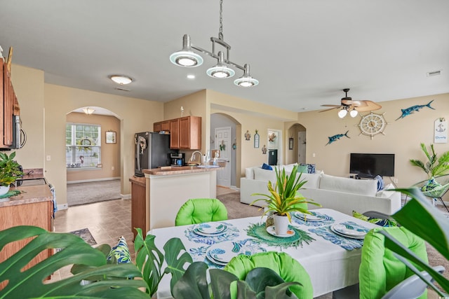 dining room featuring light carpet and ceiling fan