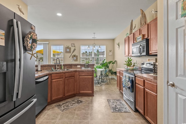 kitchen featuring stainless steel appliances, sink, light tile patterned flooring, pendant lighting, and a chandelier