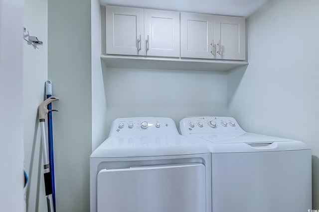 laundry room with cabinets and washer and clothes dryer