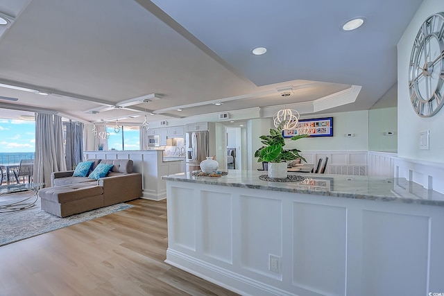 9650 Shore Dr Unit 902, Myrtle Beach, SC 29572 - kitchen with a peninsula, light wood-style floors, white cabinetry, light stone counters, and appliances with stainless steel finishes