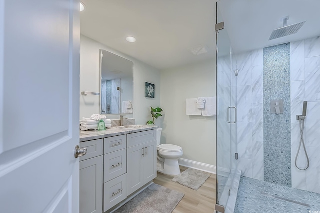 bathroom with vanity, hardwood / wood-style flooring, a shower with shower door, and toilet