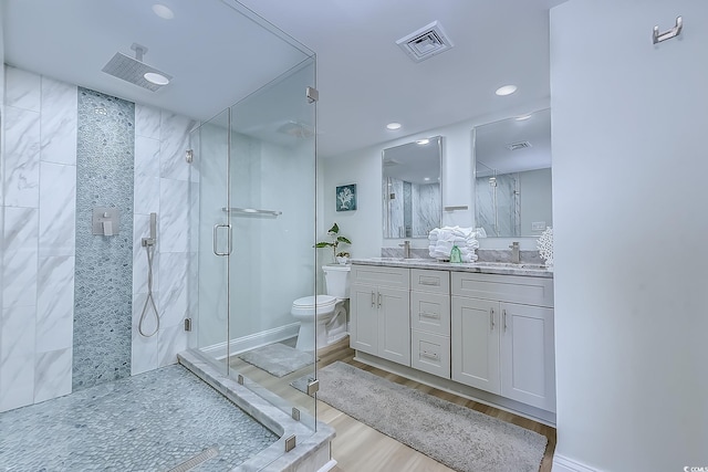 bathroom featuring walk in shower, vanity, toilet, and hardwood / wood-style flooring