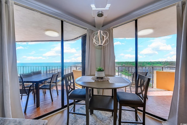 dining room featuring wood-type flooring, a water view, and floor to ceiling windows