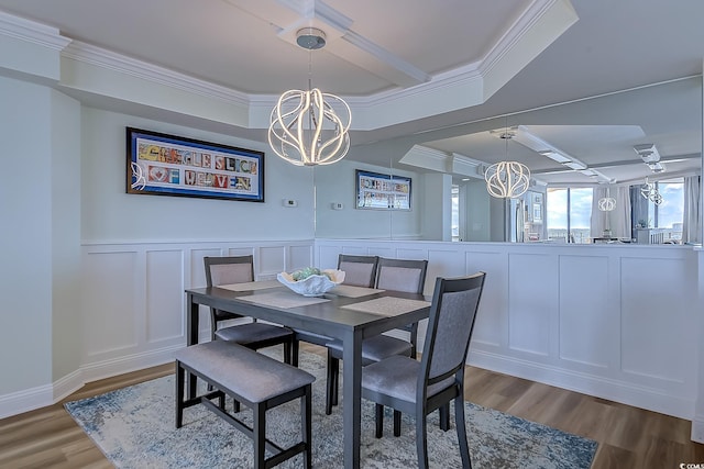 dining room with ornamental molding, an inviting chandelier, and hardwood / wood-style floors