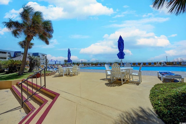 exterior space featuring a patio, a water view, and a pool