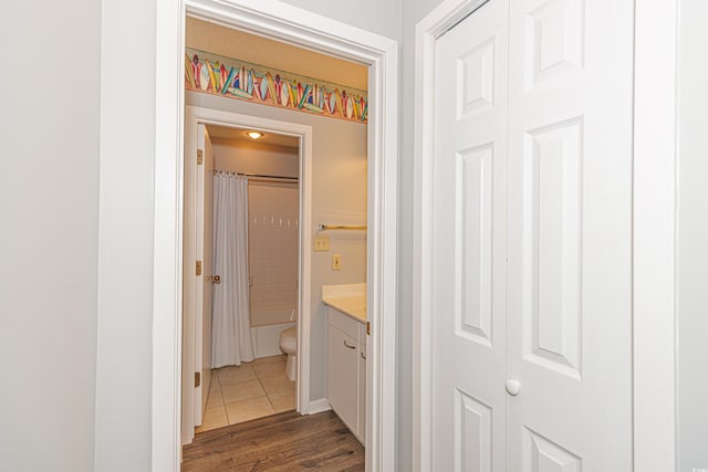 full bathroom featuring vanity, toilet, hardwood / wood-style floors, and shower / bathtub combination with curtain