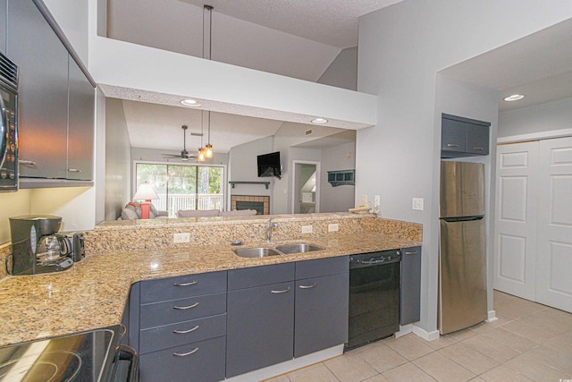 kitchen with vaulted ceiling, appliances with stainless steel finishes, sink, light tile patterned flooring, and pendant lighting