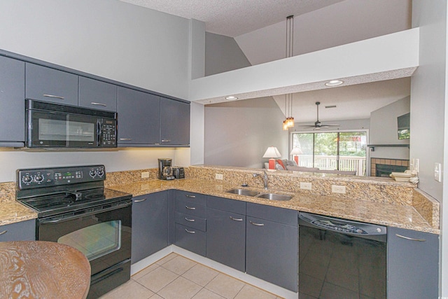 kitchen featuring a ceiling fan, light tile patterned flooring, a fireplace, a sink, and black appliances