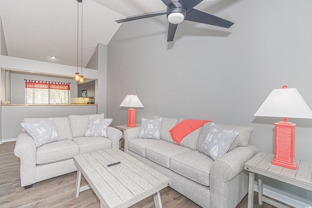 living room featuring lofted ceiling, ceiling fan, and hardwood / wood-style flooring