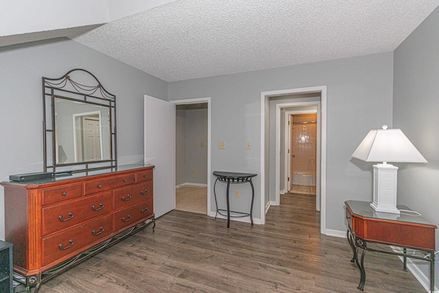 bedroom with a textured ceiling and dark hardwood / wood-style flooring