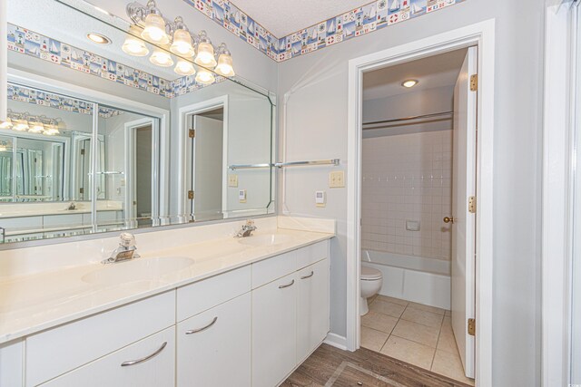 full bathroom with a textured ceiling, vanity, toilet, hardwood / wood-style flooring, and tub / shower combination