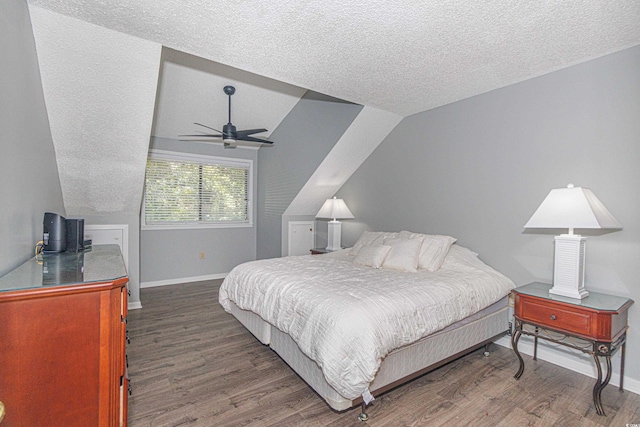 bedroom with lofted ceiling, hardwood / wood-style floors, ceiling fan, and a textured ceiling