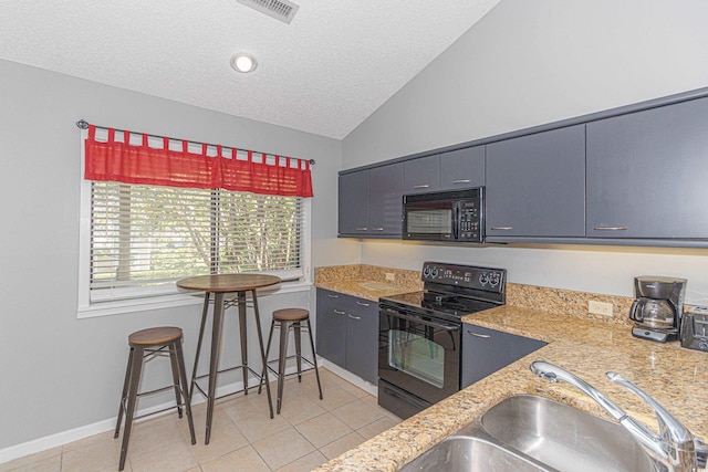 kitchen with a textured ceiling, black appliances, sink, vaulted ceiling, and light tile patterned flooring