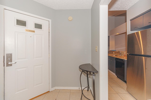 tiled entrance foyer featuring a textured ceiling and sink