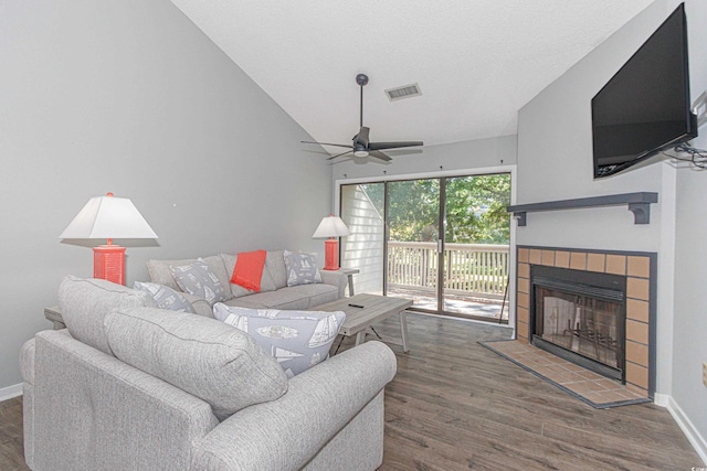 living room with a fireplace, dark wood-type flooring, lofted ceiling, and ceiling fan