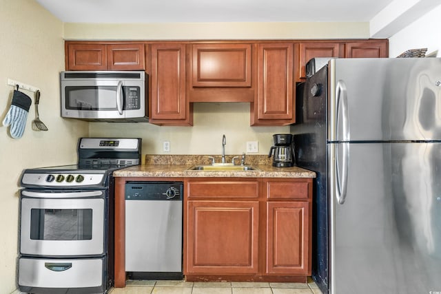 kitchen with stainless steel appliances, light tile patterned flooring, and sink