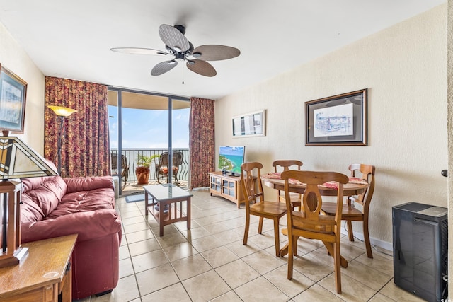 tiled living room with expansive windows and ceiling fan