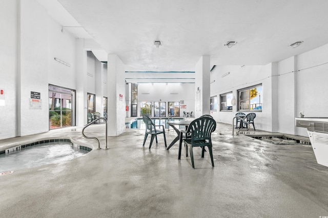 dining space featuring concrete floors and a high ceiling