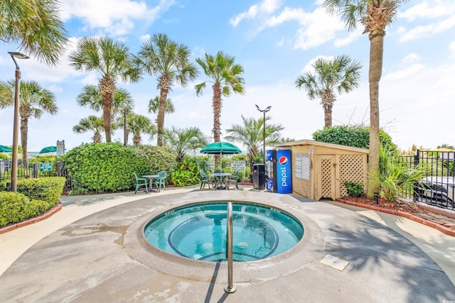 view of swimming pool with a hot tub