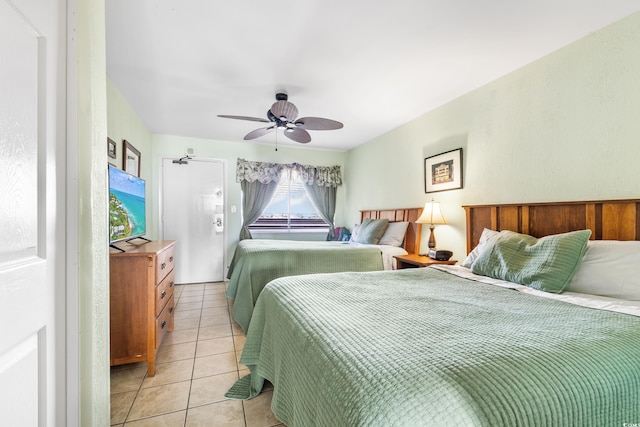 bedroom with ceiling fan and light tile patterned floors