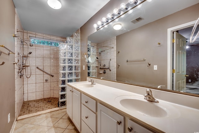 bathroom with vanity, tiled shower, and tile patterned flooring