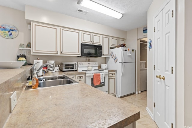 kitchen with white appliances, visible vents, light countertops, and a sink