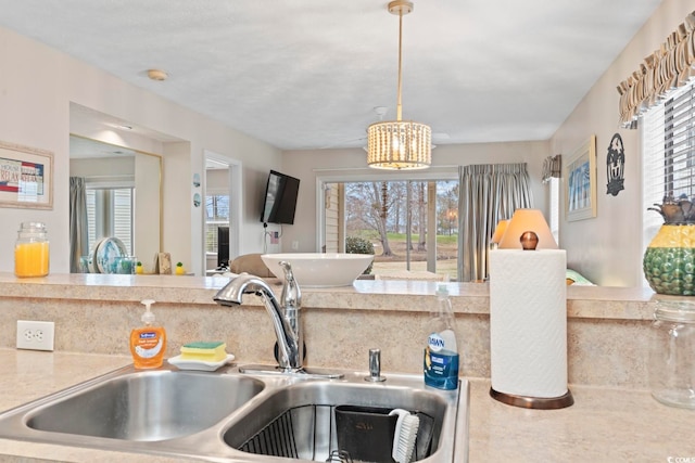 kitchen featuring decorative light fixtures, a chandelier, sink, and a wealth of natural light