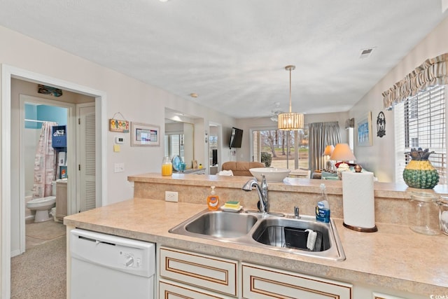 kitchen featuring pendant lighting, white dishwasher, sink, light carpet, and an inviting chandelier