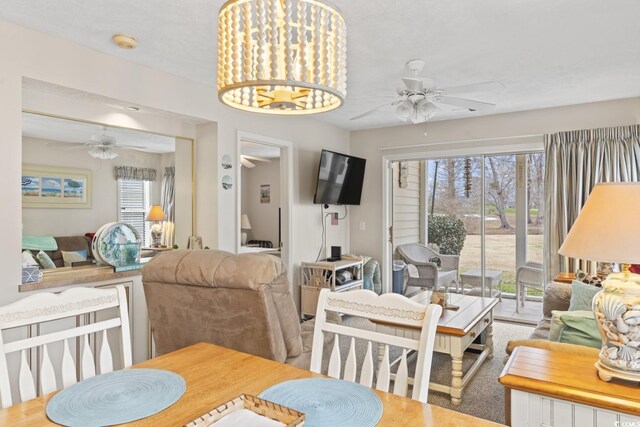 dining room with ceiling fan with notable chandelier