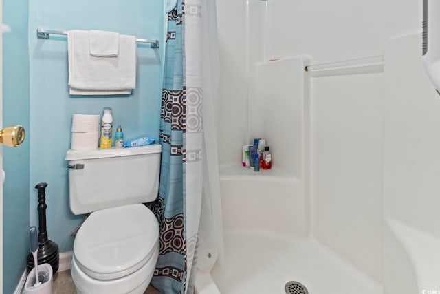 bathroom featuring toilet and curtained shower