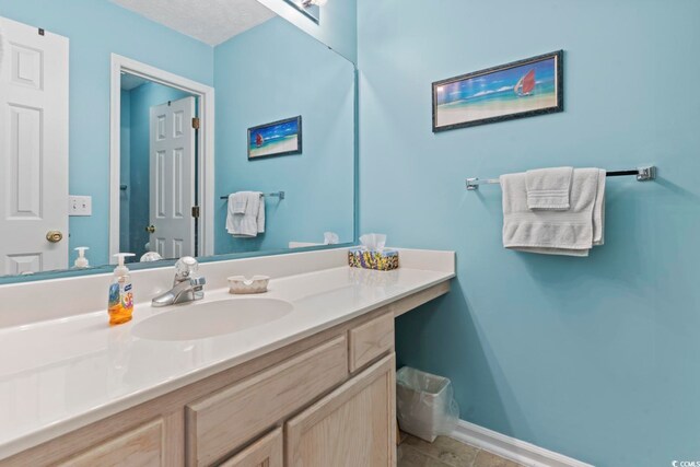 bathroom featuring a textured ceiling and vanity